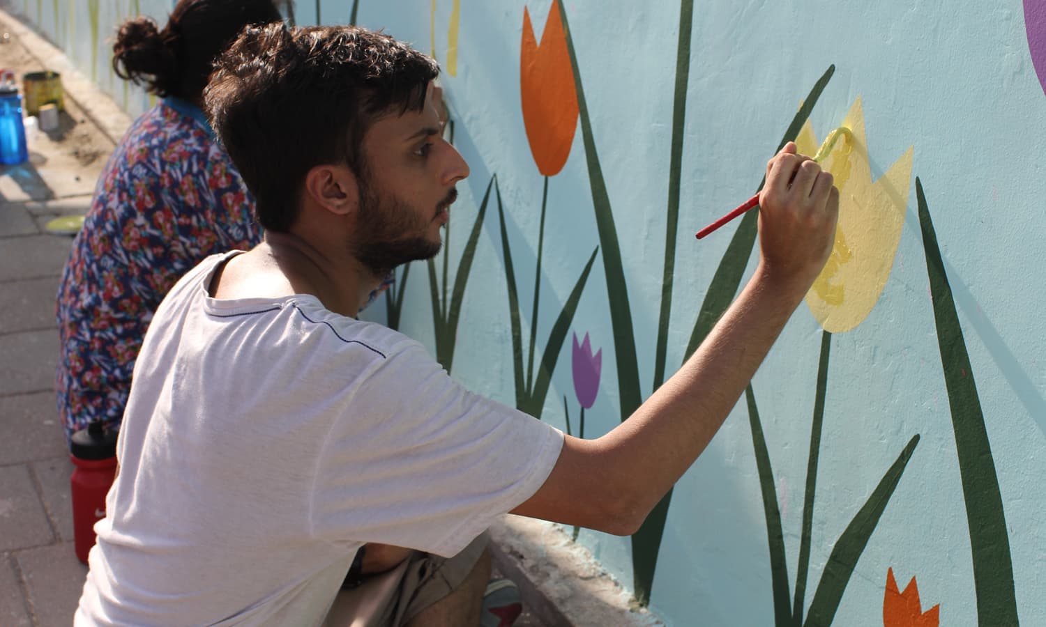 Students of Indus Valley School painting a wall at MT Khan Road, Karachi