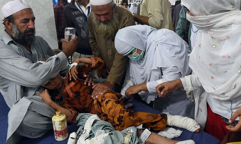 Paramedics treat a girl injured in an earthquake at a hospital in Peshawar. -AFP