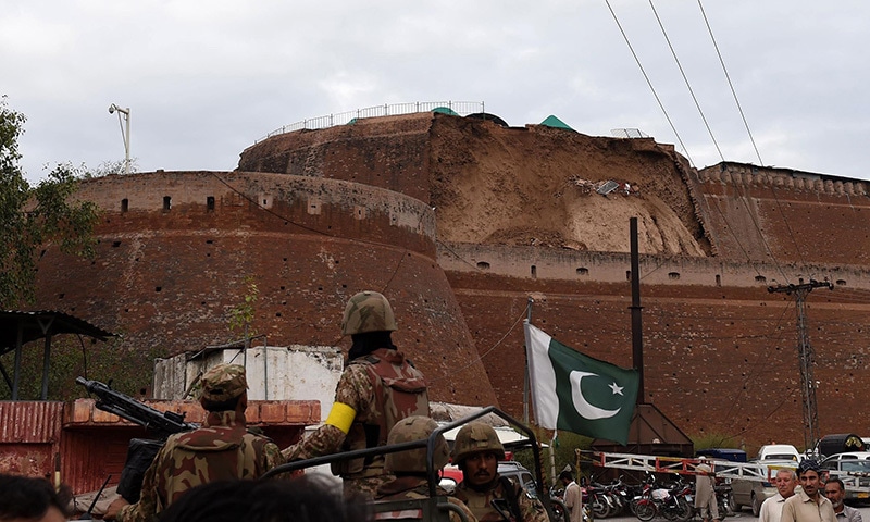 Pakistani Army soldiers observe the damaged wall of a fort used by security forces after an earthquake in Peshawar. -AFP